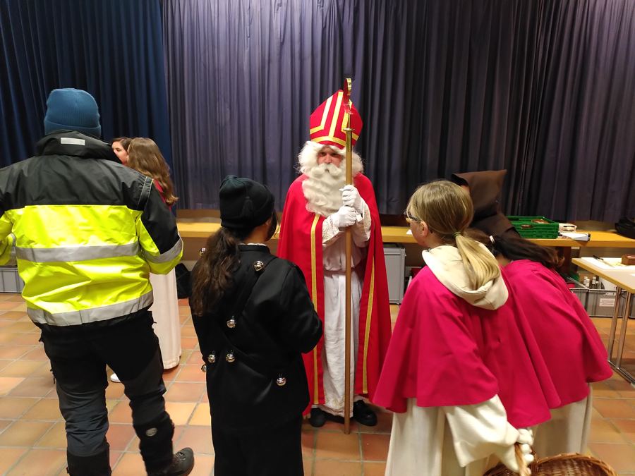 Der Samichlaus im Gespräch mit seinem Gefolge: Dienerinnen, Trychlerin und Ruprecht